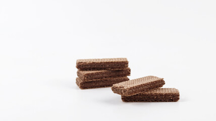 Chocolate wafer biscuits stacked and arranged on a clean white background. Crispy layered wafers with chocolate cream filling create a sweet snack concept, ideal for food advertising