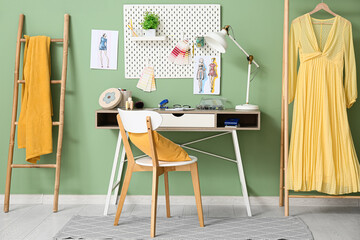 Obraz premium Workplace of fashion designer with pegboard, sketches and beautiful dress near color wall