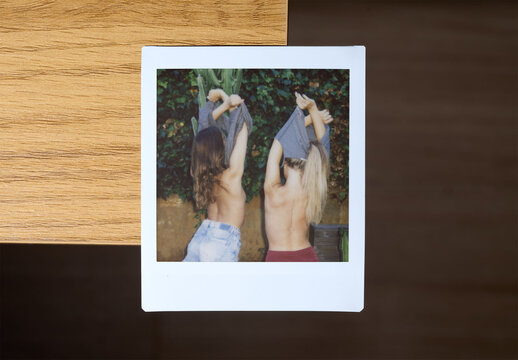 Real photo of Empty square Polaroid on Wooden Table Surface. PSD template mockup 