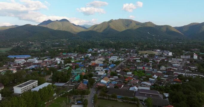 Scenic Town Of Pai In The Valley Surrounded By Forested Mountains In Mae Hong Son, Thailand, At Sunset. wide aerial shot