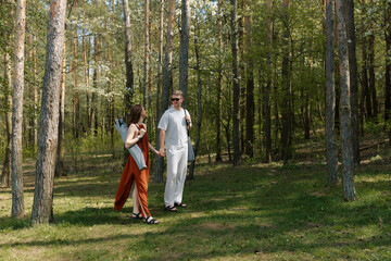 Fototapeta premium Couple enjoys a leisurely walk in a serene forest during daytime in spring