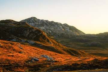 Grand panoramic view from Prutas peak at sunset, overlooking the dramatic limestone ridges and deep valleys of Durmitor National Park, Montenegro.