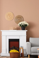 Naklejka premium Fireplace and chrysanthemums near beige wall in room