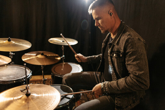 Man practicing drums during band rehearsal.