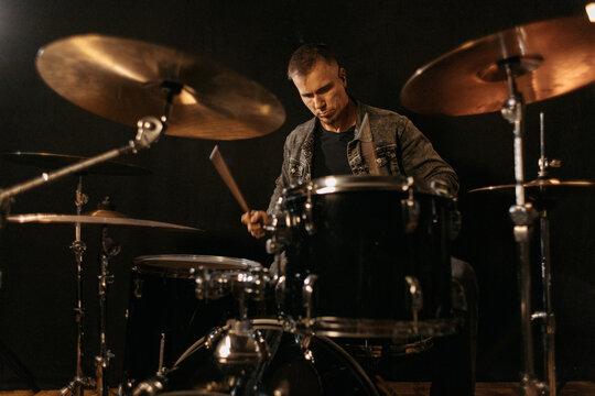 Musician practicing drums during rehearsal session.