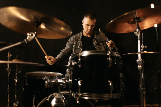 Musician practicing drums during rehearsal session.