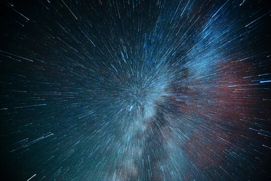 Abstract space background with stars stretching into light speed lines