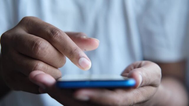Close up of person using index finger to scroll through digital content on blue smartphone screen