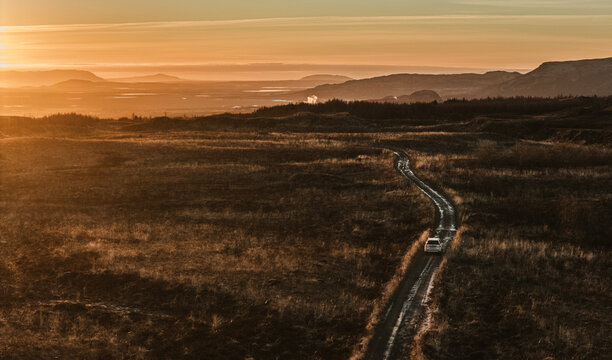 Aerial of SUV driving dirt F road through interior of Iceland.