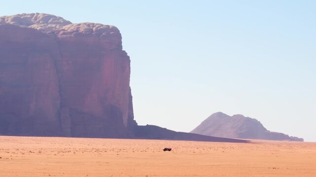 Water delivery truck crossing Wadi rum desert beneath sandstone cliffs remote supply logistics water scarcity arid survival concept Jordan