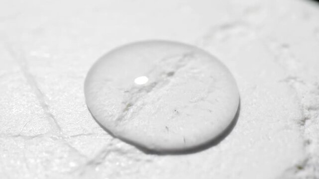 Water Droplet on White Marble Surface Closeup.