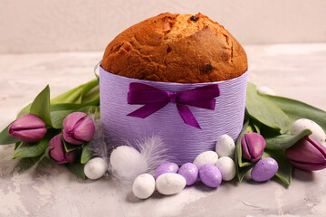 Delicious Easter cake with eggs and tulip flowers on beige background
