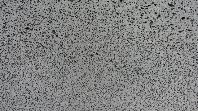 Gray concrete wall texture with porous surface pattern