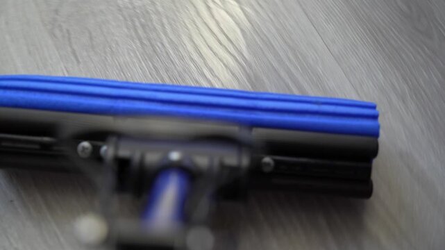 Clean floor with blue vacuum attachment at home in daylight hours