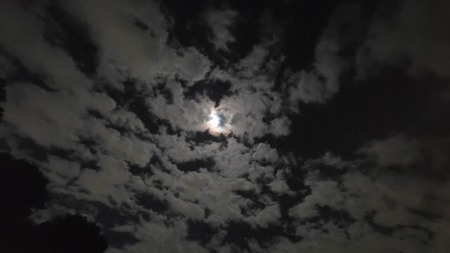 雲の後ろに輝く夜の月 夜空に浮かぶ幻想的な月光