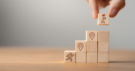 Arranging wooden blocks with icons for career path and development strategy concept. Success roadmap and journey symbolizing structured growth, planning, and progress. © Aytana