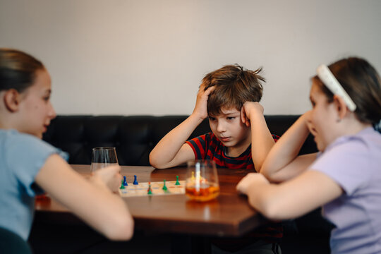 Children playing board game feeling frustration