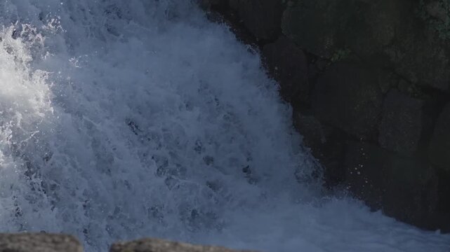 White foaming water rushing over rocks in natural stream