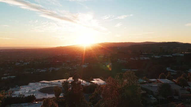 Aerial low dolly shot of mansions and estates at sunset in Beverly Hills, California. 4K