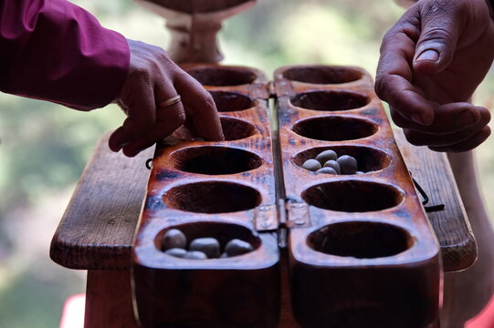 Closeup of man hands playing Ouri, mancala family of games, Cape Verde