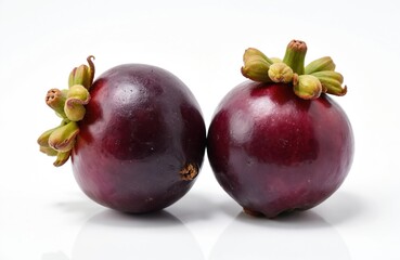 Obraz premium Two ripe mangosteen fruits displayed on white backdrop. This exotic fruit offers sweet, juicy segments perfect for healthy eating or tropical recipes. Use for food blogs, health content, or recipes.