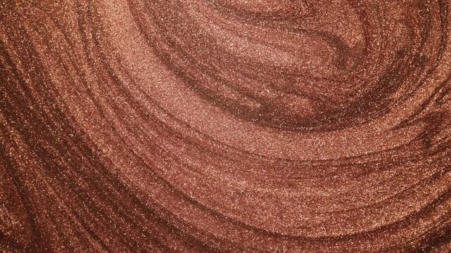 Smoothly swirling close-up of copper paint with specialized sandy texture forming curved ridges and flowing slowly while shimmering with glitter particles on an abstract background