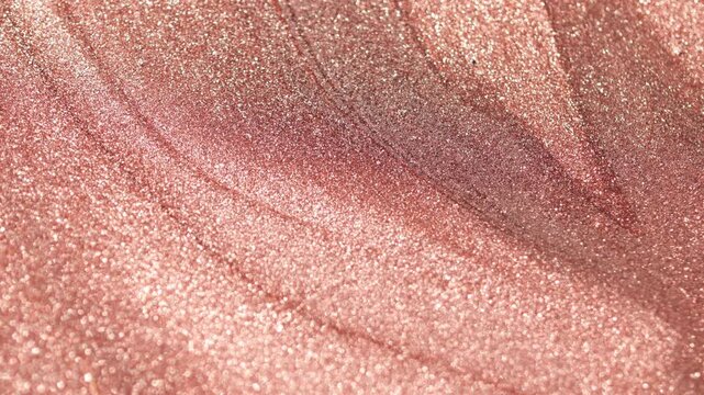 Macro view of copper paint with sandy texture and sparkling particles rotating and shimmering under light on metallic background