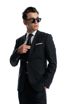 Cool man adjusting jacket and looking away
