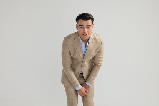 Interested man in beige suit leaning forward