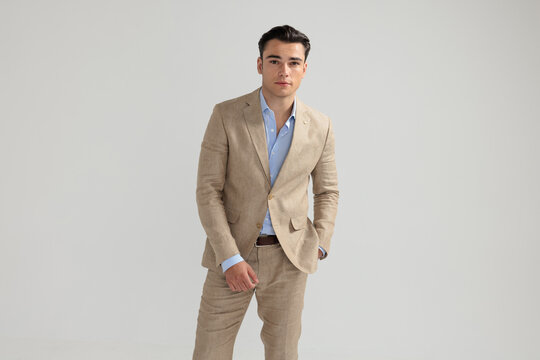Handsome man posing in beige suit with hand in pocket