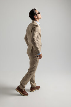 Side view of confident man walking and looking up
