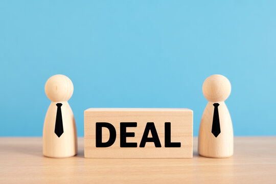 Wooden figures with a deal sign represent negotiation agreement and business concepts.