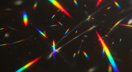 Vibrant rainbow light refractions on a sleek black background with colorful beams and sparkles © Hridoy