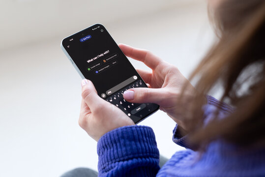 Kyiv, Ukraine, March 7, 2025. Woman using ChatGPT AI chatbot on smartphone, typing message in mobile app, modern artificial intelligence technology