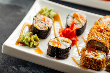 Close up sushi rolls with sesame nori rice and ginger served on white plate with sauce © Hihitetlin