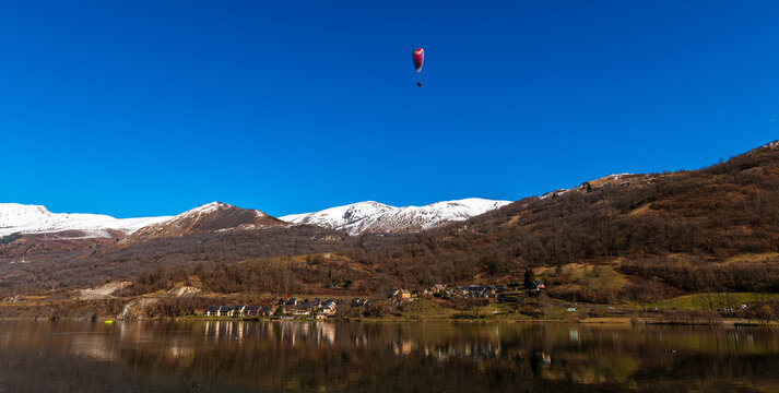 Paraglider at Lake G&eacute;nos-Loudenvielle and the Pyrenees, in the Hautes-Pyr&eacute;n&eacute;es, Occitanie, France