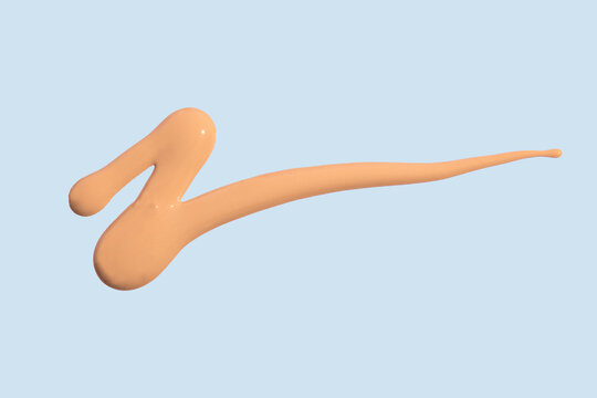 Liquid foundation swatch on blue background with copy space