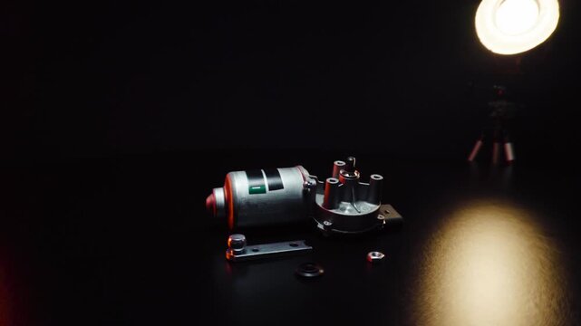 new electric motor for car wipers for windshield cleaning, repair at the service, shooting in a dark room, red light illumination