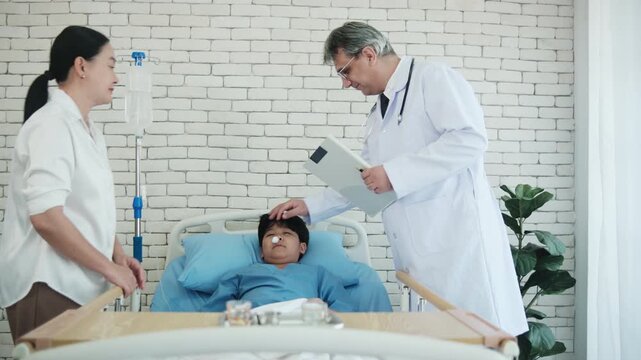 Professional White doctor visits, exams, and checkups sick Asian patient boy in pediatric hospital ward, child illness healthcare consultation and medic physician, diagnosis advice to parent worried.