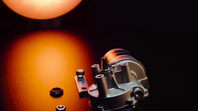 new electric motor for car wipers for windshield cleaning, repair at the service, shooting in a dark room, red light illumination