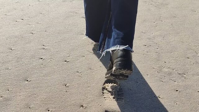 Close Up Boots Walking on Beach Sand Toward Ocean