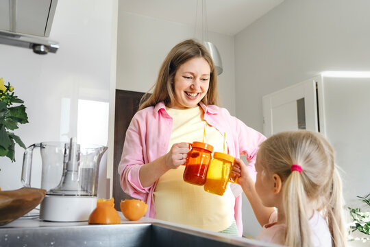 Pregnant woman enjoying time with daughter in kitchen at home