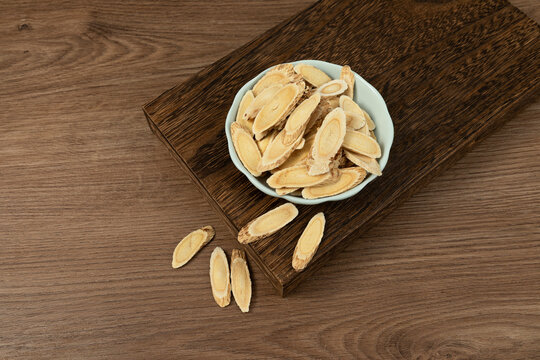 Astragalus Slices in Celadon Bowl on Wooden Table