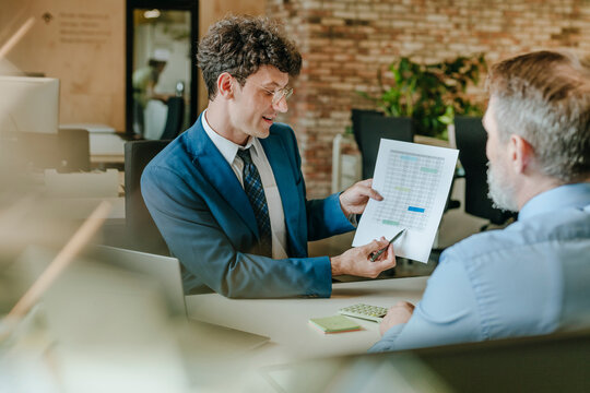 Business consultant presenting financial charts to client during office meeting