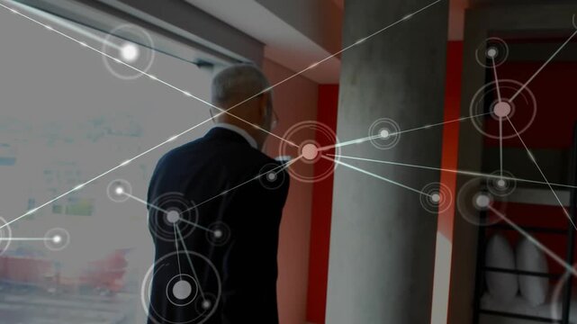 Exec entering room pulling case, pausing, using phone for call, inserting earbud, network growing