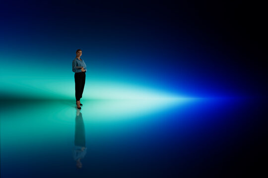 Businesswoman standing blue glow scene with reflective floor
