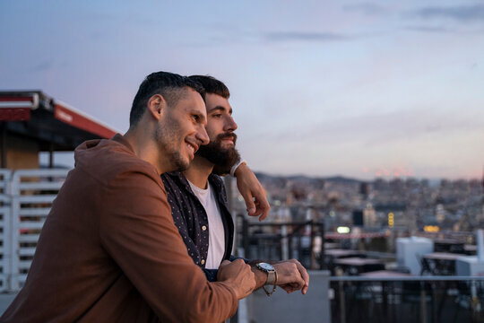 Gay couple on lookout above the city, Barcelona, Spain