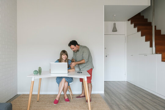 Couple with credit card and laptop in modern flat