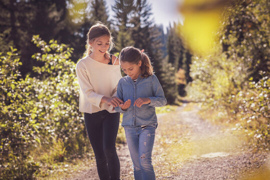 Two sisters walking on forest path