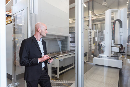 Businessman looking at machine in modern factory
